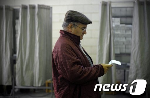 21일(현지시간) 스페인 북부 갈리시아의 비고시(市)에 위치한 투표소에서 한 남성이 투표 용지를 쳐다 보고 있다. © AFP=News1
