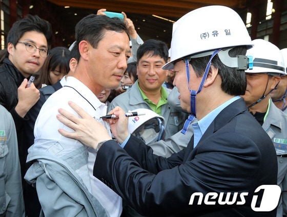 무소속 안철수 대선후보가 3일 전남 영암군 대불산업단지내 (주)유일 1공장을 찾아 한 근로자의 상의에 사인을 해주고 있다. 안 후보는 이날 여수시 돌산읍 태풍피해 양식장을 살펴보는 것을 시작으로 2박3일 일정으로 호남을 방문해, 민생현장 탐방에 나선다. 2012.10.3/뉴스1 © News1 이종덕 기자