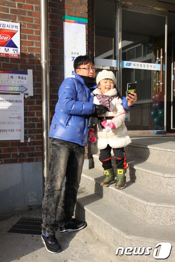 대전 대덕구 법동 벙동중학교에서 투표를 마친 부녀가 인증샷을 찍고 있다.© News1 송원석 기자