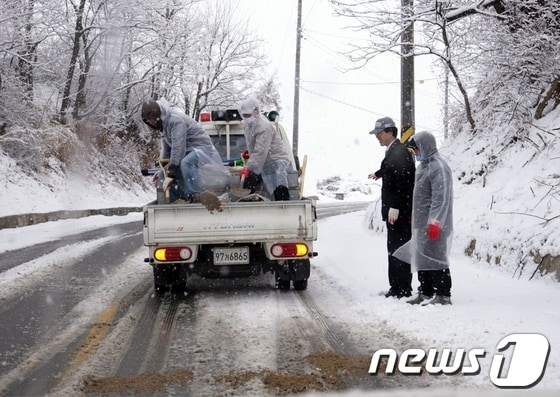 28일 내린 폭설로 가지산으로 이어지는 도로 등이 교통통제된 가운데 밀양시 제설작업반이 모래를 뿌리고 있다. <밀양시 제공>© News1 