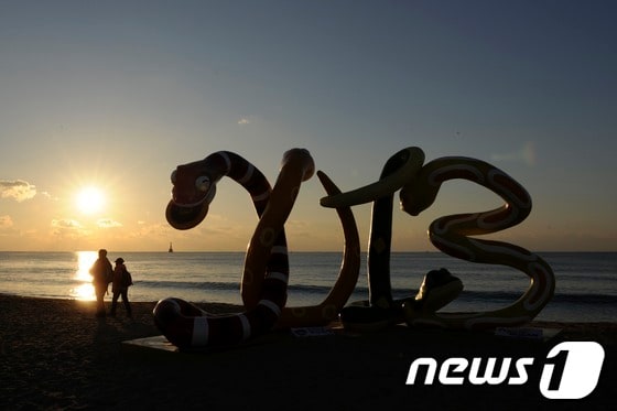 임진년 마지막날인 31일 부산 해운대구 해수욕장에 2013년 계사년을 기념하는 조형물 뒤로 해가 떠오르고 있다. 한국천문연구원이 밝힌 해운대해수욕장의 새해 첫날 해뜨는 시각은 오전 7시 31분이다. 2012.12.31/뉴스1 © News1   전혜원 기자