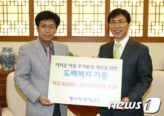 송의섭회장이 14일 안희정도지사에게 벽지 기증서를 전달하고 있다© News1 