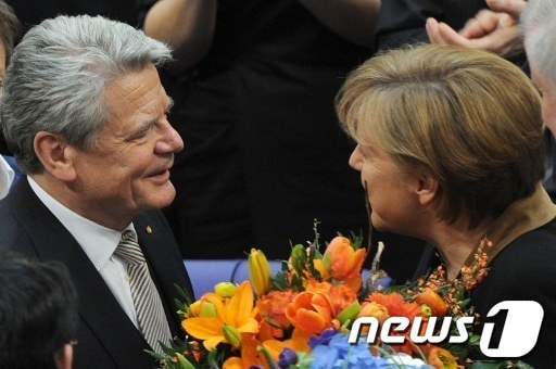 요아힘 가우크 새 독일 대통령이 18일 연방총회에서 대통령으로 선출된 후 앙겔라 메르켈 총리로부터 축하를 받고 있다. © AFP=News1