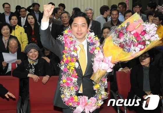 서울 중구 정호준 민주통합당 후보가 서울 신당동 선거사무소에서 사실상 당선이 확정되자 지지자들에게 꽃다발을 받으며 기뻐하고 있다. © News1 