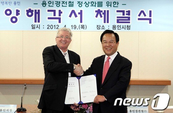 19일 용인시청 정책토론실에서 열린 경전철 정상화를 위한 양해각서 체결식에 참석한 김학규 용인시장(사진 오른쪽)과 Serge Bission(써지 비숀) 봄바디어 트랜스포테이션코리아(주) 사장 겸 용인경전철(주) 이사가 양해각서 체결 후 기념촬영을 하고 있다./© News1