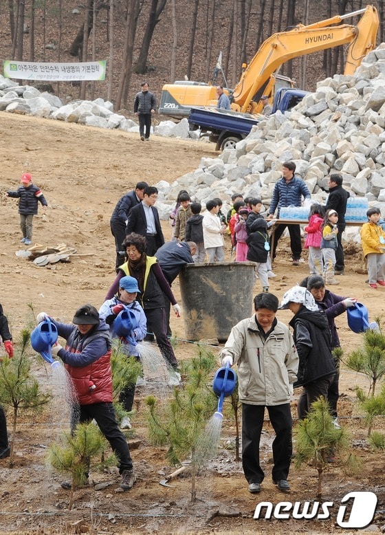 식목일을 사흘 앞둔 2일 오전 서울 서초구 우면산 복구현장에서 열린 ‘뿌리깊은 나무 심기’ 행사에 참가한 주민들이 소나무에 물을 주고 있다. © News1   이정선 인턴기자