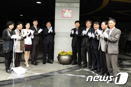 울산 중구와 마제스타워아파트 부녀회는 25일 마제스타워 정문에서 자원봉사 홈타운 행복나눔터 6호점 협약 및 현판식을 가졌다. (사진=울산 중구청 제공) © News1