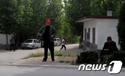 중국 시각장애 인권변호사 천광청이 가택연금 도중 탈출한 산동성 이난현 동스구 마을 앞에서 사복경찰들이 경비를 서고 있다. © AFP=News1