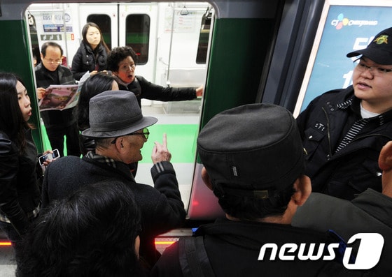  서울 지하철 2호선 운행이 중단된 6일 승객들이 멈춰선 열차 앞에서 역 관계자에게 항의하고 있다.© News1 오대일 기자