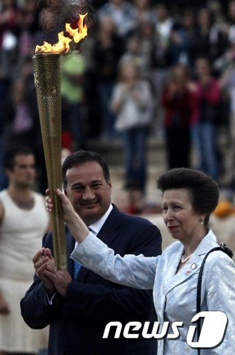 영국 앤공주가 17일(현지시간) 그리스 아테네 올림픽 스타디움에서 열린 성화 전달식에서 런던 올림픽 성화를 건네받고 있다. © AFP=News1 