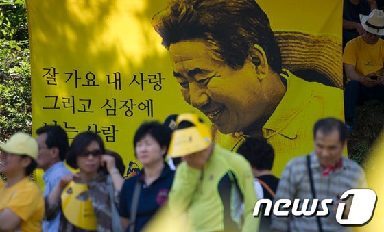 故 노무현 전 대통령 3주기 추모식이 열린 지난 2012년 5월 23일 경남 김해 봉하마을에서 추모객들이 노 전 대통령의 생전사진을 보며 추모식장으로 들어서고 있다. 2012.5.23/뉴스1
