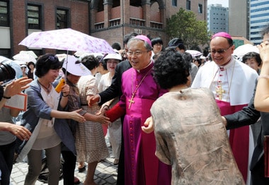 서울대교구가 25일 오후 명동대성당에서 제14대 서울대교구장 염수정 대주교의 착좌 미사를 봉헌하고 있다. 착좌 미사 전 염수정 대주교가 신도과 인사를 나누며 성당으로 들어서고 있다. 이날 미사는 오스발도 파딜랴 교황대사와 전임 교구장인 정진석 추기경, 한국 교회 주교단과 서울대교구 사제단이 공동 집전하며, 착좌미사와 축하식, 축하연 순으로 진행된다.2012.6.25/뉴스1 © News1   이동원 기자