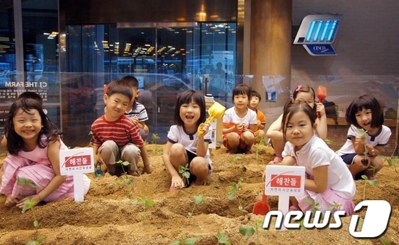 지난 6월 28일 CJ식품연구소 'CJ The Farm'에서 열린 '자연의 시간표대로' 체험행사에 참여한 어린이들이 콩을 심고 있다. © News1