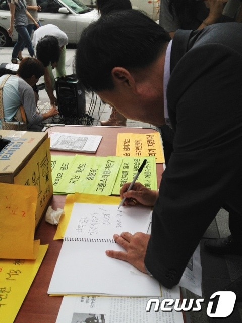 부좌현 민주통합당 소속 현병철 후보자 인사청문회 위원이 13일 오후1시 현병철 인권위원장 연임반대와 국가인원귀 바로세우기 전국 긴급행동의 천막 자진철거 기자회견에 참석해 방명록에 글을 남기고 있다. © News1 