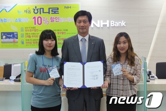 농협은행 김양권 영업부장(가운데)과 목포대학교 김정하, 박지원 학생의 연수협약체결 모습./사진제공=농협© News1