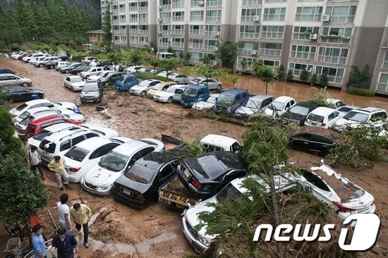 12일 밤부터 13일 오전 6시까지 전북 군산지역을 중심으로 최대 시간당 130mm가 넘는 국지성 폭우가 쏟아져 비 피해가 속출했다. 사진은 소룡동 아파트 인근에서 토사가 유실돼 차량이 매몰된 모습이다. 2012.8.13/뉴스1 © News1 김재수