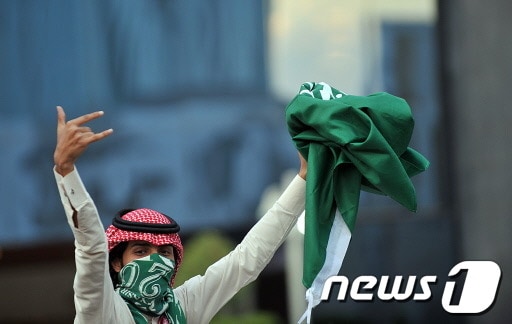 한 사우디아라비아 여성이 국가기념일을 맞이해 국기를 들고 환호하고 있다. (기사 내용과 관련 없음) ©AFP=News1 