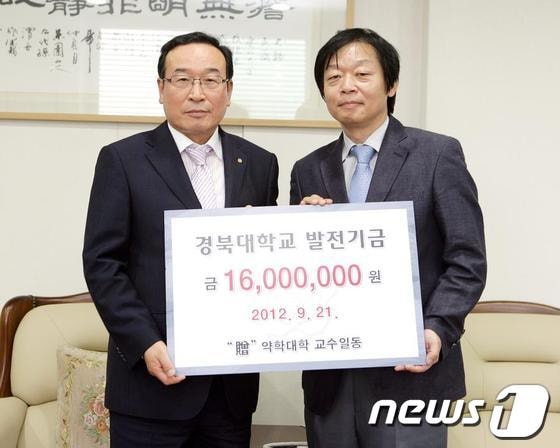송경식 경북대 약학대학장(오른쪽)이 함인석 총장에게 발전기금을 전달하고 있다./사진제공=경북대© News1