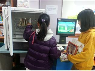 한 아이가 서울 도봉도서관에 설치된 책소독기를 이용하고 있다. (서울시교육청 제공) © News1