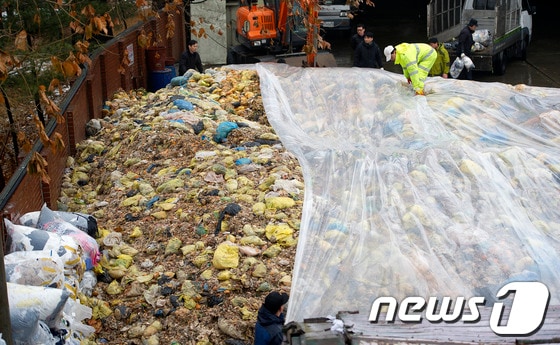  21일 서울 관악구 음식물쓰레기 중간 집하장에서 비를 막기 위해 비닐로 쓰레기를 덮고 있다. 2013.1.21/뉴스1 © News1 이명근 기자