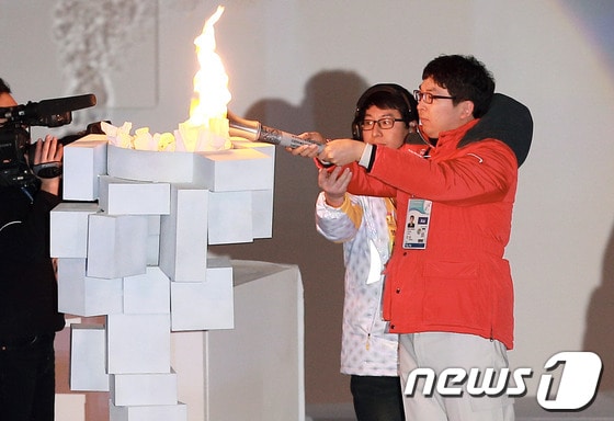 전 세계 지적 장애인들의 겨울축제 &#39;2013 평창동계스페셜올림픽&#39;이 막을 올린 29일 강원도 평창군 용평돔에서 열린 개막식에서 대한민국 스노보드 황석일 선수가 성화를 점화하고 있다. 2013.1.29/뉴스1 © News1   오대일 기자