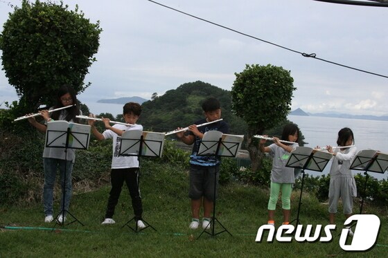 바다를 뒤로 하고 플루트 연주를 들려준 곤리 분교의 미니 합주단. 좌측부터 황주영(6학년), 이재균(6학년), 김태웅(5학년), 김채희(3학년), 이재영(1학년) © News1