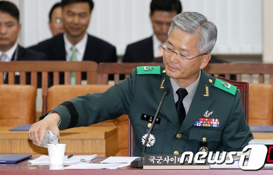 옥도경 국군사이버사령부 사령관이 15일 오후 서울 여의도 국회 국방위원회에서 열린 국군사이버사령부 국정감사에서 물을 컵에 따르고 있다. 2013.10.15/뉴스1 © News1 허경 기자