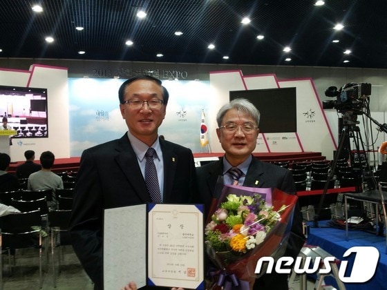 이규훈 광주대 LINC사업단단장(왼쪽)과 최완석 부단장이 23일 우수상을 받아들고 환하게 웃고 있다/사진제공=광주대© News1 