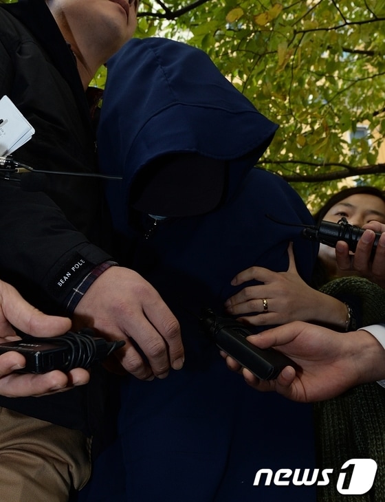 거짓말을 한다며 8살 된 딸을 때려 숨지게 한 계모 박모(40)씨가 30일 오전 울산시 울주군 범서읍 자신의 아파트에서 현장검증 후 쏟아지는 취재진의 질문에 고개를 숙이고 있다. 2013.10.30/뉴스1 © News1 노화정 기자