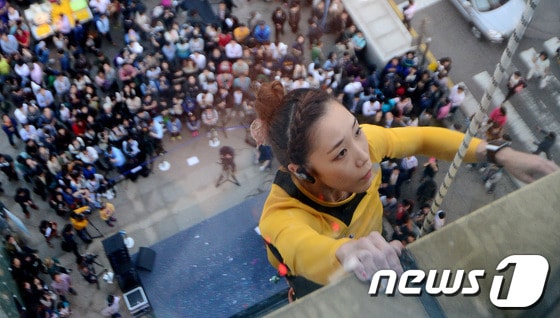 한국 스포츠 클라이밍의 간판 스타 김자인이 4일 오후 서울 명동 롯데백화점 본점 에비뉴엘에서 열린 '카스 라이트 빌더링2' 행사에서 백화점 건물을 오르고 있다. 빌더링(Buildering)은 빌딩(Building)과 스포츠 클라이밍의 한 종목인 볼더링(Bouldering)의 합성어로, 도심의 빌딩 벽을 오르는 것을 뜻한다. 2013.10.4 © News1 손형주 기자