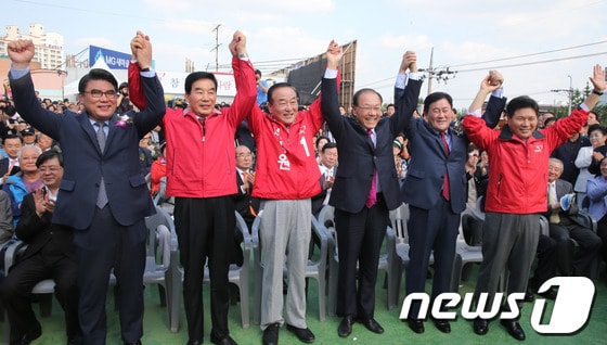 황우여 새누리당 대표와 최경환 원내대표, 경기 화성갑 보궐선거에 출마한 서청원 후보 등이 지난 9일 경기 화성시 봉담읍에서 열린 서 후보의 선거사무소 개소식에서 손을 맞잡고 참석자들에게 인사를 하고 있다.  © News1 