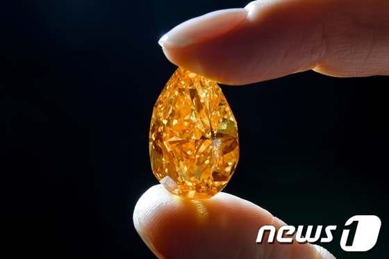 12일(현지시간) 스위스 제네바의 크리스티 경매에서 3150만달러(약 337억8400만원)에 낙찰된 세계 최대 크기의 오렌지색 다이아몬드인 '더 오렌지'의 모습. 더 오렌지의 무게는 14.82캐럿이다.© AFP=News1 