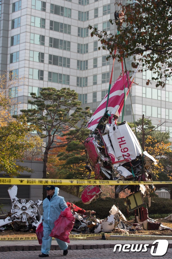 16일 오전 서울 삼성동 아이파크 아파트에 민간 헬리콥터가 충돌해 추락하는 사고가 발생했다. 이날 오후 인부들이 추락한 헬기 잔해를 인양하고 있다.이 사고로 기장 1명과 부기장 1명이 사망한 것으로 알려졌다. 2013.11.16/뉴스1 © News1   유승관 기자