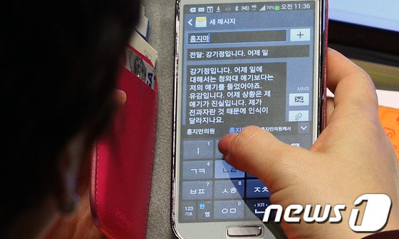 새누리당 강은희 의원이 19일 국회에서 열린 정치분야 대정부질문 도중 청와대 경호 지원요원과의 폭력사태로 논란의 중심에 선 민주당 강기정 의원이 보낸 문자메시지를 바라보고 있다. 2013.11.19/뉴스1 © News1 오대일 기자