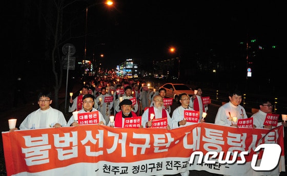 국가기관의 불법 대선 부정선거 규탄과 박근혜 대통령 사퇴를 촉구하는 시국미사가 열린 22일 오후 천주교정의구현사제단 신부들과 신자들이 전북 군산시 수송동 롯데마트 앞으로 걸어가며 '대통령 사퇴' 구호를 외치고 있다.각 종교계의 시국미사는 여러번 있었지만 대통령 사퇴를 촉구하는것은 이번이 처음이다.2013.11.22/뉴스1  © News1   김대웅 기자