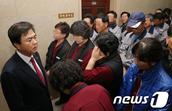 김태흠 새누리당 의원이 26일 서울 여의도 국회 운영위원장실 앞에 모인 비정규직 국회 청소용역 노동자들과 대화를 하고 있다.   김 의원은 이날 국회 운영위원회 전체회의에서 국회 청소용역 노동자의 정규직 전환 요구를 두고 