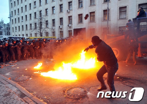 지난 1일(현지시간) 우크라이나 수도 키예프에서 열린 반정부시위에서 한 시위대원이 경찰을 향해 화염병을 던지고 있다.© AFP=News1