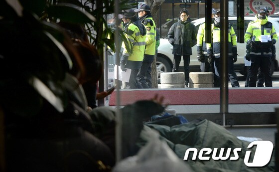 철도노조 노조원들과 민주노총 관계자 등이 21일 오전 민주노총이 입주한 서울 중구 정동 경향신문사 로비에서 경찰이 철도노조 지도부 등에 대한 검거를 위해 들이닥칠 것을 대비해 출입구 등을 지키고 있다. 2013.12.21/뉴스1 © News1 박정호 기자