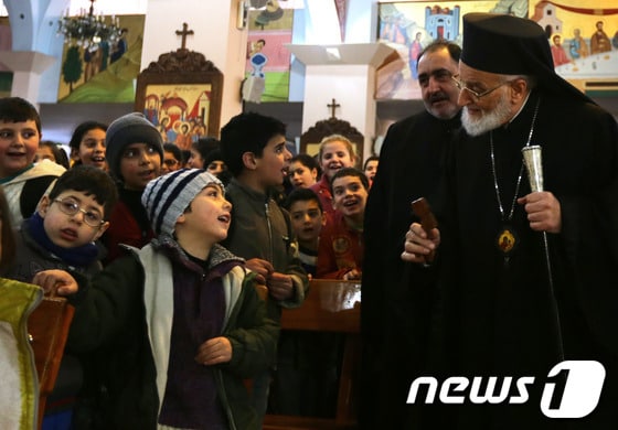 다마스쿠스의 한 교회에서 시리아 말룰라 난민을 위해 예배를 집도한 그레고리오스 3세 라함 동방정교 대주교와 난민 어린이들의 모습.© AFP=News1