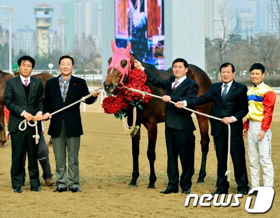 8일 과천 서울경마공원에서 열린 서울사회복지공동모금회 연말나눔 캠페인에서 경주마 `지금이순간'이 사랑의 열매를 받은 뒤 최성룡(왼쪽 둘째) 마주와 지용철(〃 셋째)감독,  문세영(〃 첫째)선수 등과 기념사진을 찍고 있다./사진제공=한국마사회© News1
