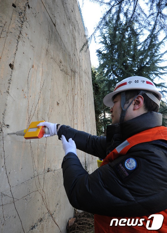 해빙기를 맞아 대구 수성구 생활 안전과 직원들이 건축물의 안전사고를 예방하기 위해 21일 오전 대구 수성구 한 아파트 옹벽을 슈미트 해머를 이용해 콘크리트의 강도를 측정하고 있다. 2013.02.21/뉴스1 © News1 김영진 기자