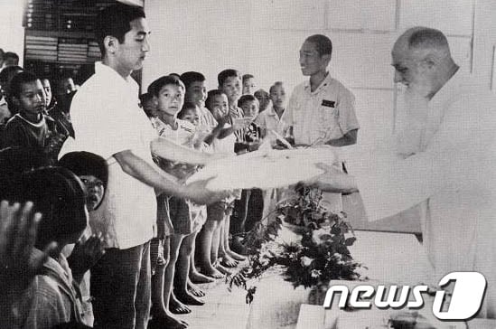 남대영 신부가 고아들에게 선물을 전달하고 있는 모습./사진제공=포항시© News1 