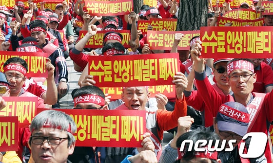 13일 오후 서울 여의도 산업은행 앞에서 열린 대한통운 택배노동자 생존권 쟁취 결의대회에서 참석자들이 수수료 인상과 패널티 폐지를 촉구하고 있다. 2013.5.13/뉴스1 © News1   허경 기자