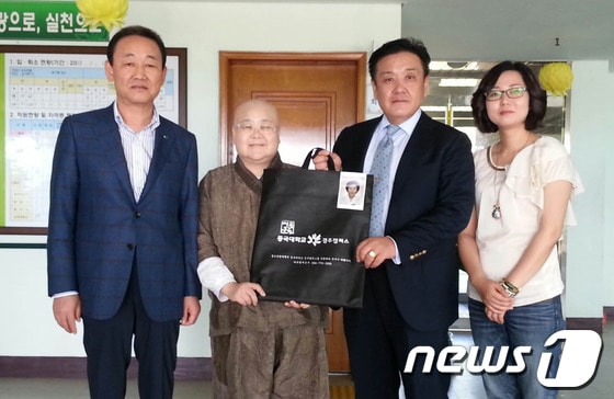 최정훈 동국대 경주캠퍼스 대외협력부본부장(오른쪽두번째)가 요양원 대표인 무공스님에게 영장사진을 전달하고 있다./사진제공=동국대경주캠퍼스© News1 