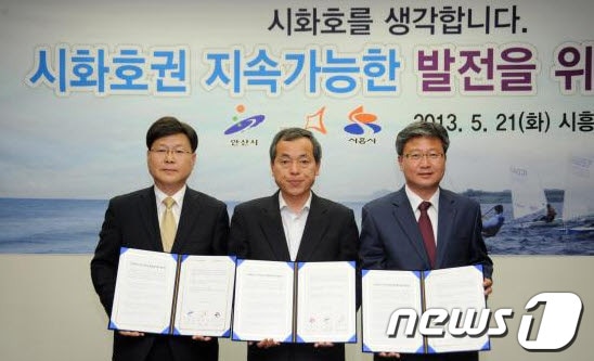김윤식 시흥시장(가운데 )와 채인석 화성시장(오른쪽), 정승봉 안산시 부시장(왼쪽) 등이 21일 시흥시청에서 시화호권 지속가능한 발전을 위한 업무협약을 한 뒤 기념사진을 찍고 있다./사진제공=시흥시© News1