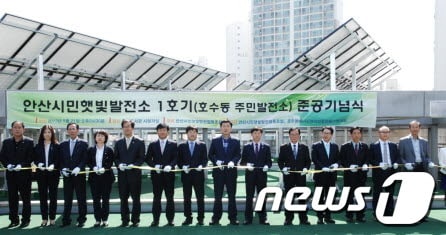 김철민 안산시장 등이 21일 호수동 중앙도서관에서 열린 시민햇빛발전소 준공식에 참석해 기념 테이프를 자르고 있다./사진제공=안산시© News1