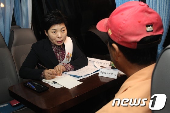 오순명 금융감독원 금융소비자보호처장이 22일 새벽 금융사랑방버스를 타고 남구로역의 새벽 인력시장을 방문, 한 일용직 근로자에게 금융상담을 해주고 있다.(사진제공=금융감독원)© News1