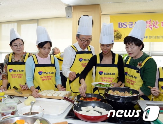 이장호 BS금융그룹 회장(가운데)이 결혼이주여성 등과 함께 요리를 하고 있다./사진제공=BS금융그룹 © News1