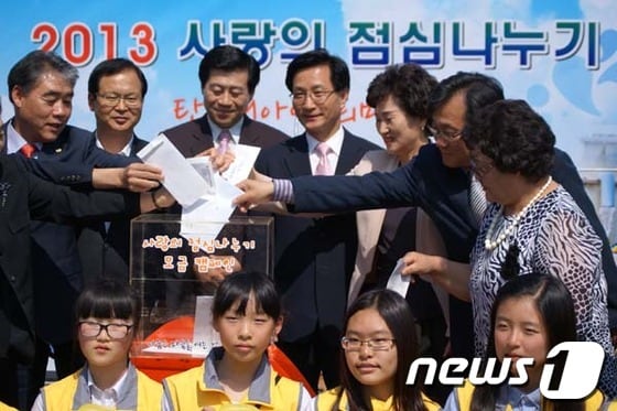 22일 오후 2시 강릉시청 임영대종각 앞에서 진행된 사랑의 점심 나누기 행사에 최명희 강릉시장(왼쪽에서 4번째)이 후원금을 넣고있다 © News1
