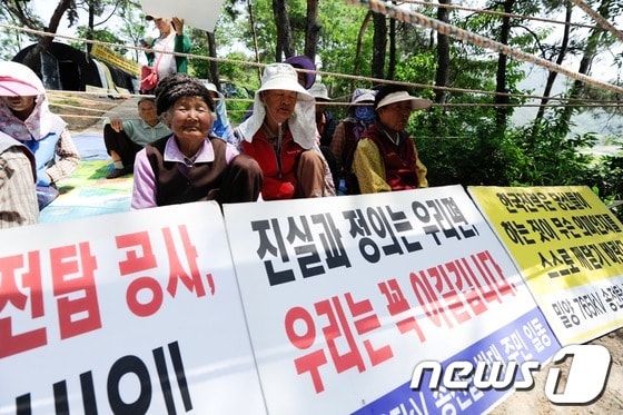 한전이 밀양지역 765kV 송전탑 공사를 닷새째 이어간 24일 오전 밀양 부북면 평밭마을 입구에 마을 주민들이 피켓을 들고 농성을 이어나가고 있다. 2013.5.24/뉴스1 © News1 전혜원 기자